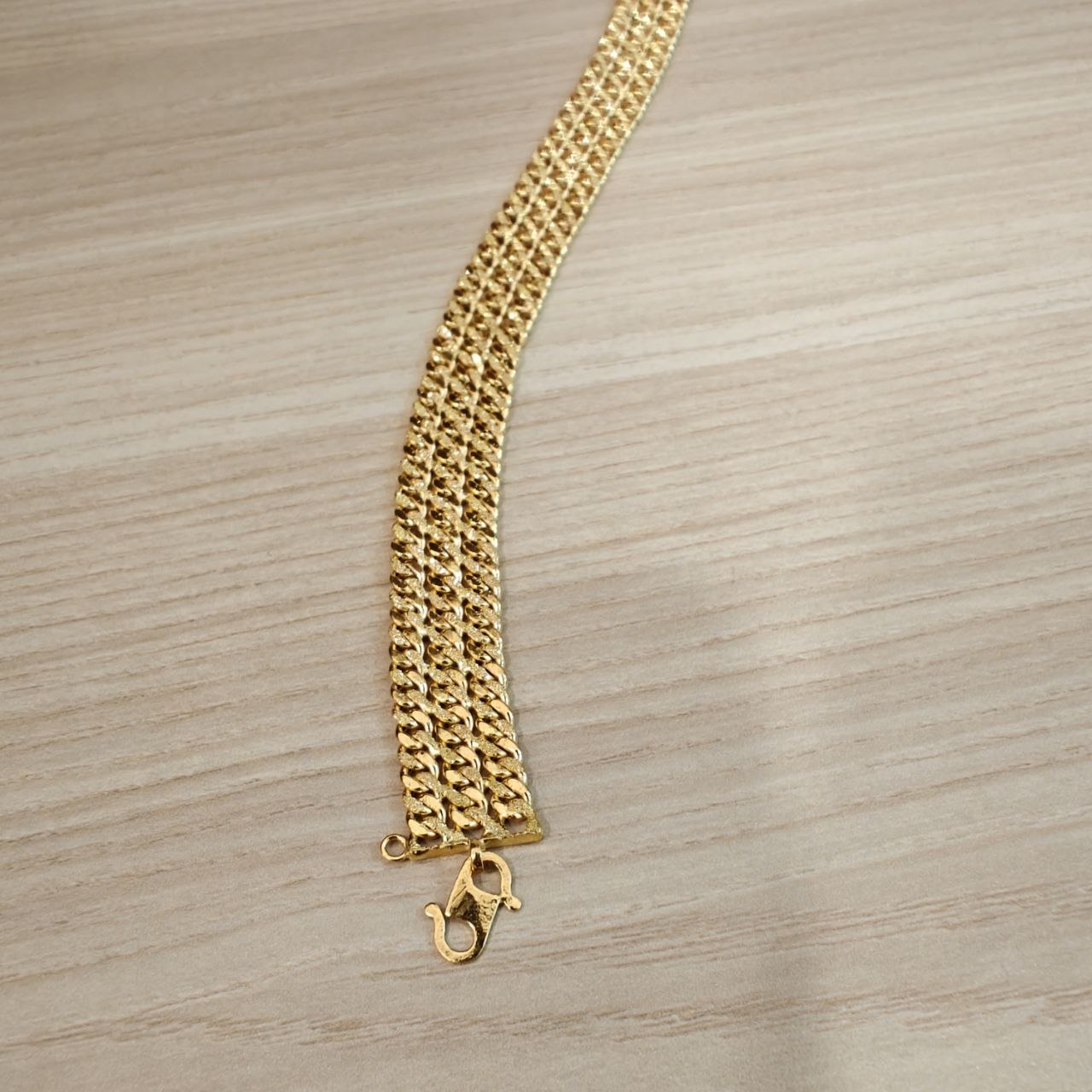 Close-up texture of polished 22K Gold Triplet Cowboy bracelet links.