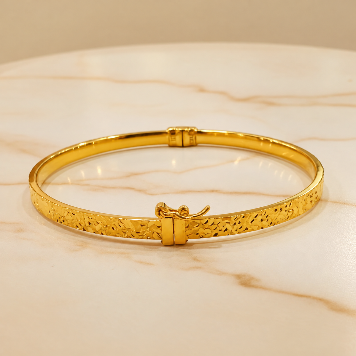 916 gold patterned slim bangle showing front hook and floral cut finish