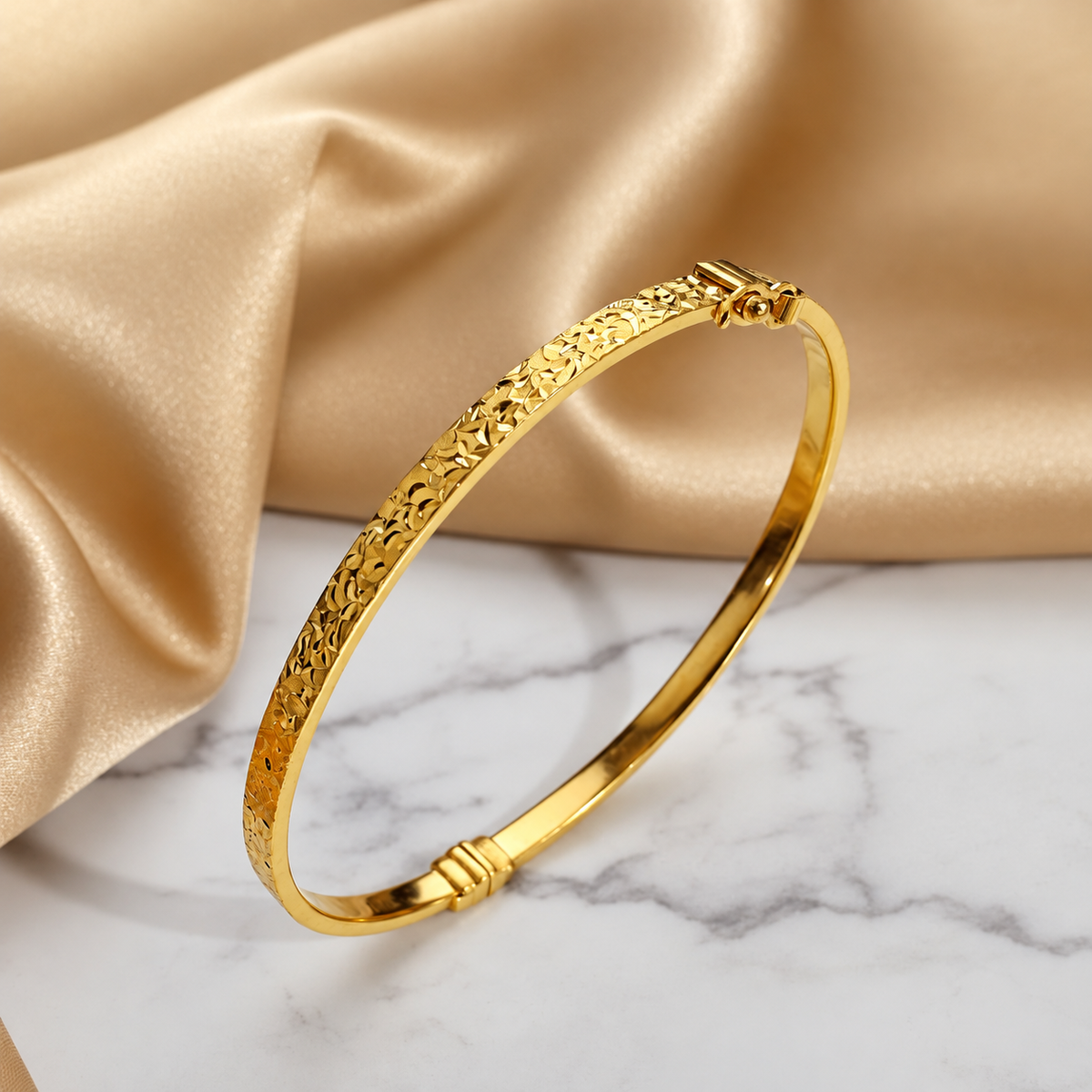 916 gold patterned slim bangle with floral facets on satin and marble