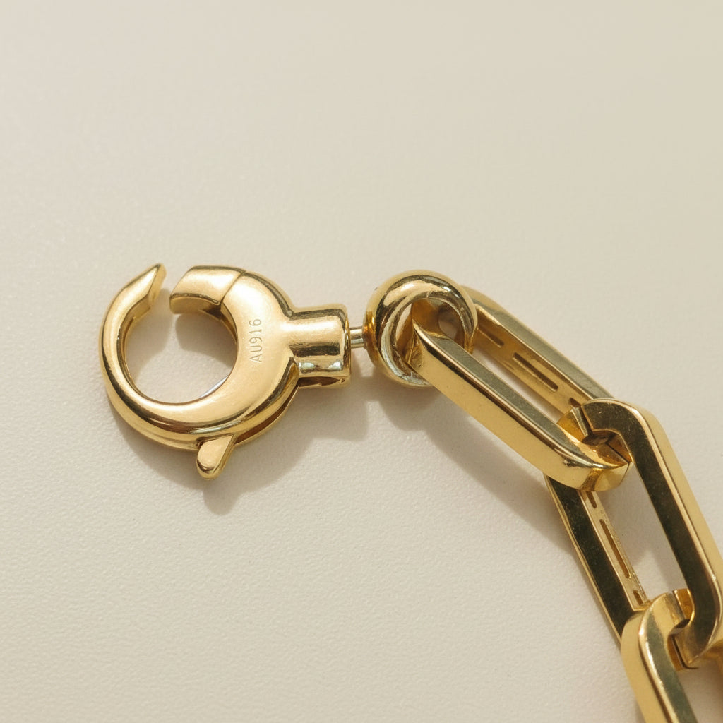 Close-up of 916 gold bracelet dangling heart charm