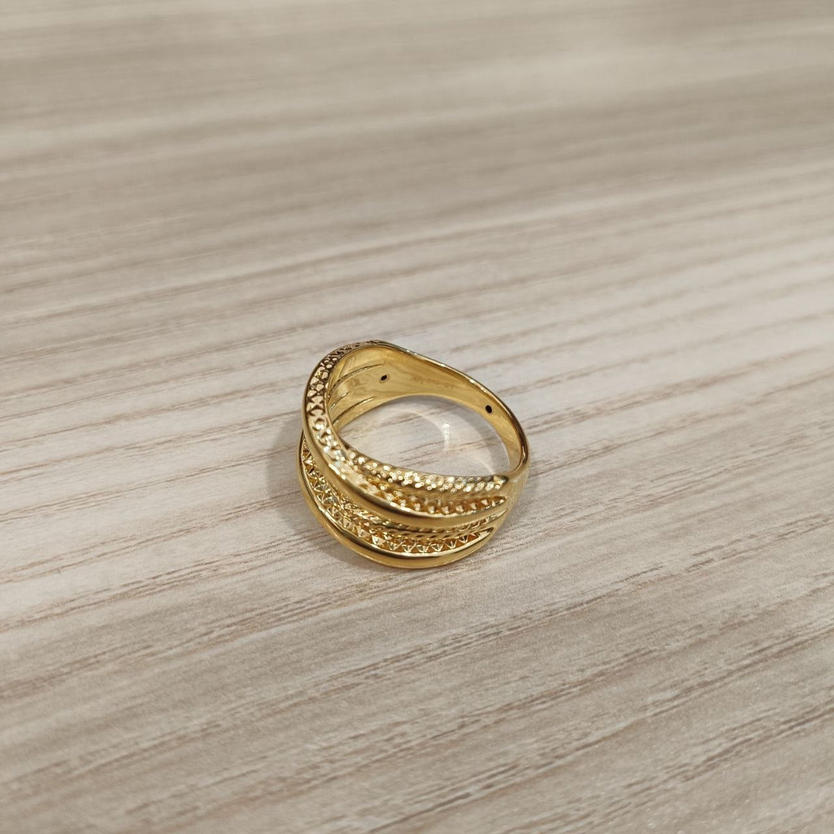 Close-up of textured 916 gold double cross ring details