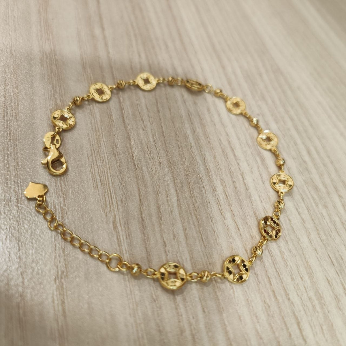 Adjustable 916 gold geometric round motif bracelet angled view
