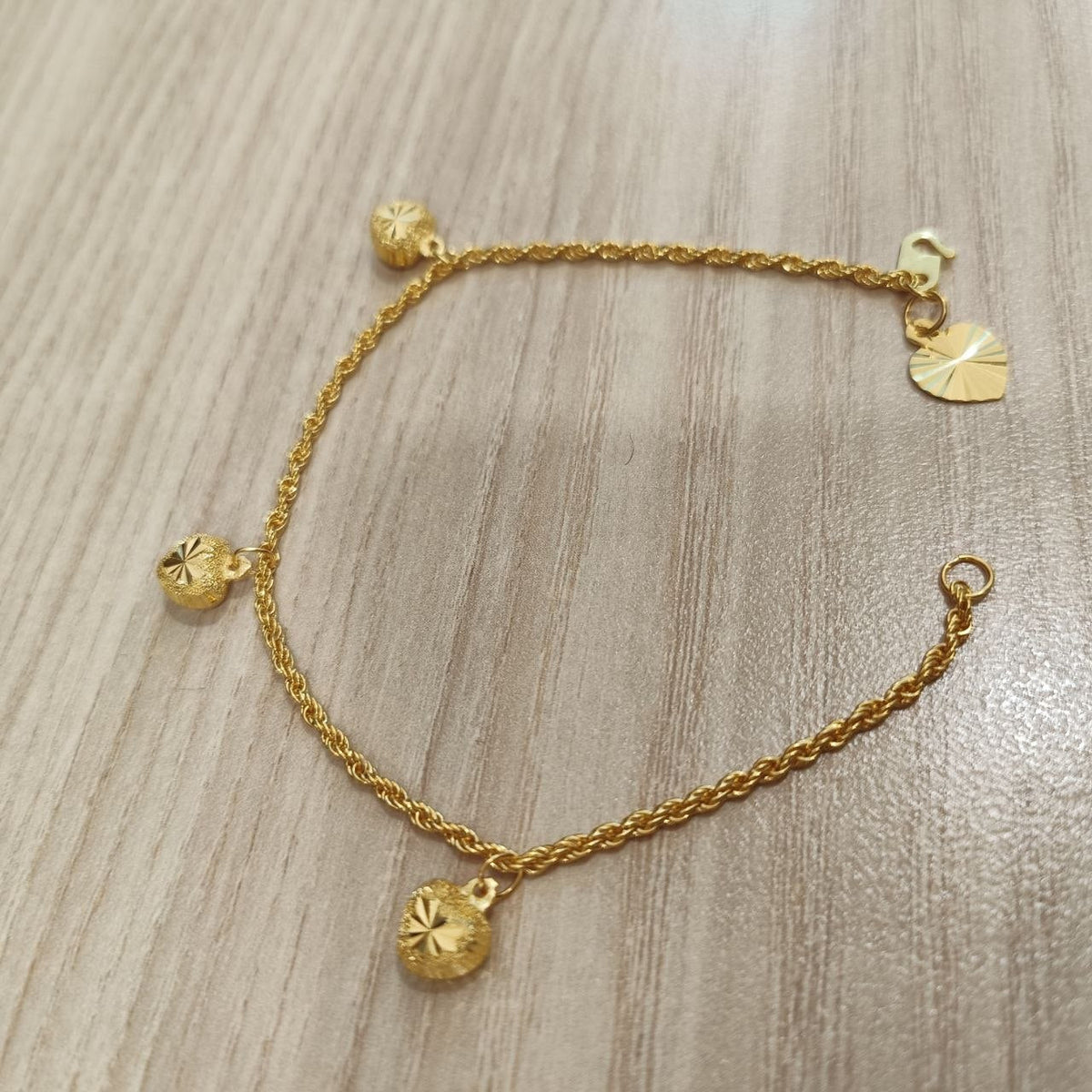 916 Gold hollow rope bracelet and heart charms angled view