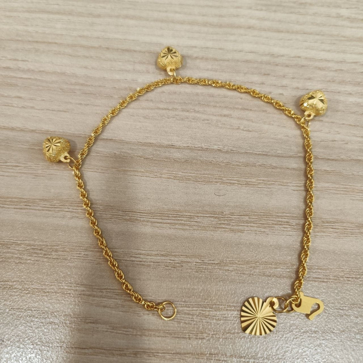 916 Gold hollow rope bracelet showing heart charms and clasp