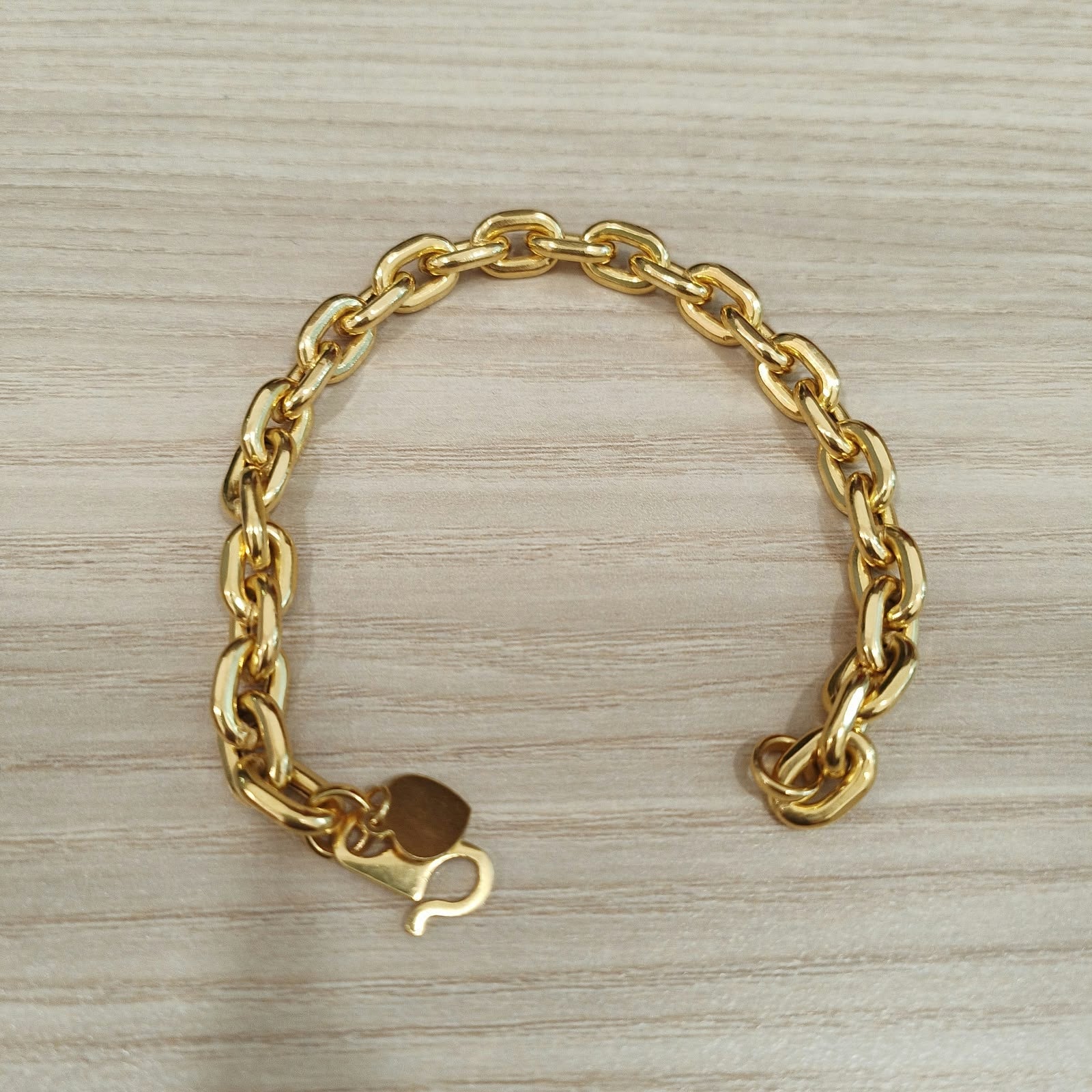 Close-up of polished 916 gold hollow Wanzi bracelet links
