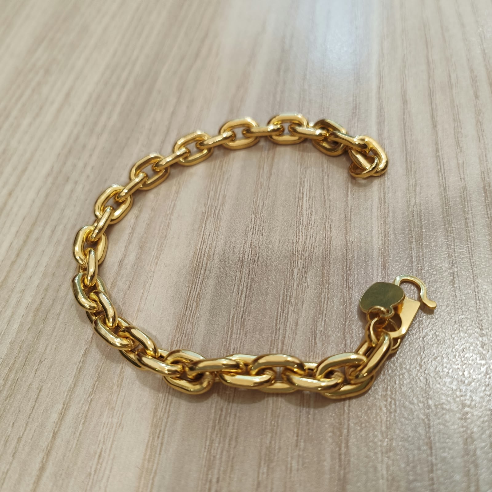 Side view of polished 916 gold hollow Wanzi bracelet