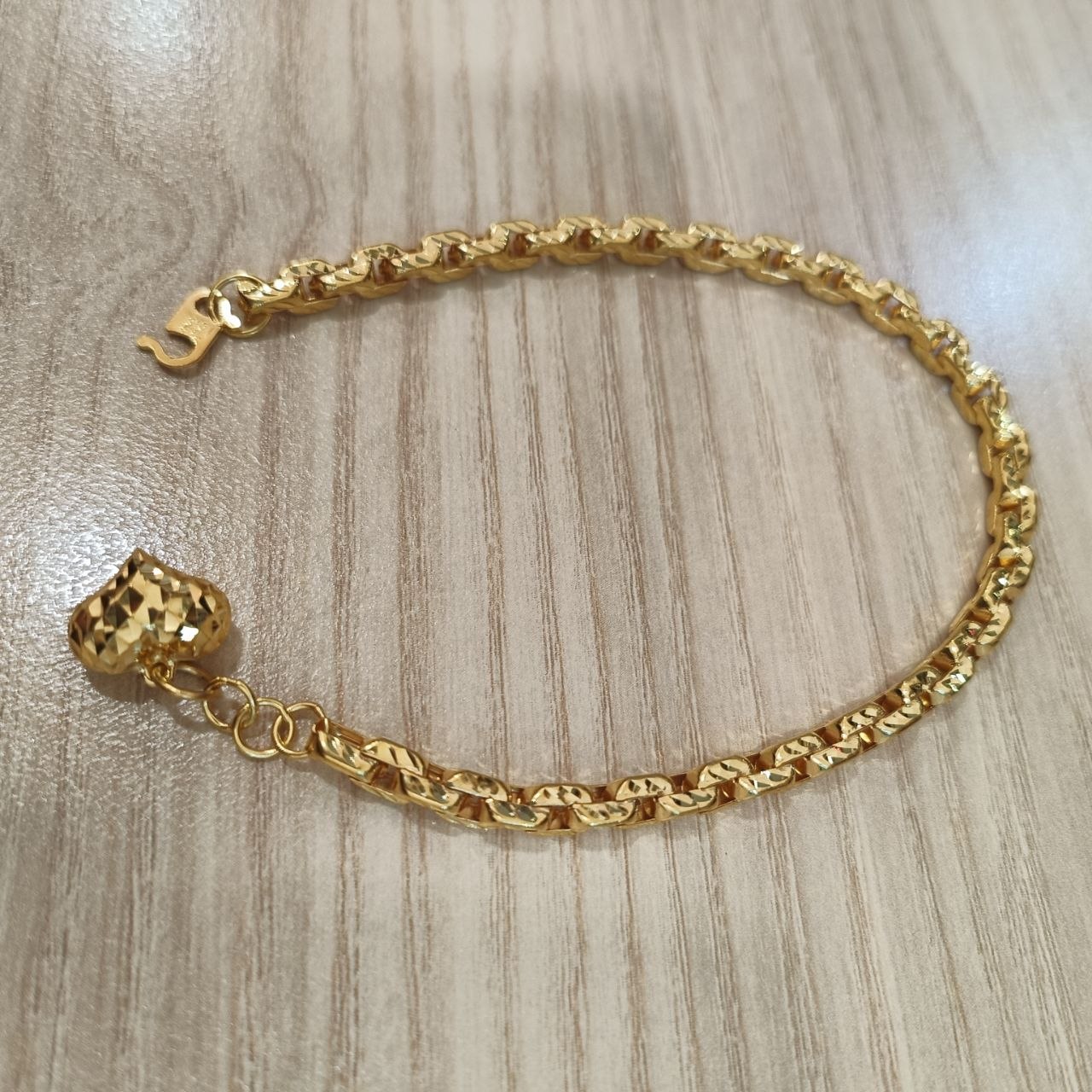 Detailed view of the polished hollow heart-shaped gold links