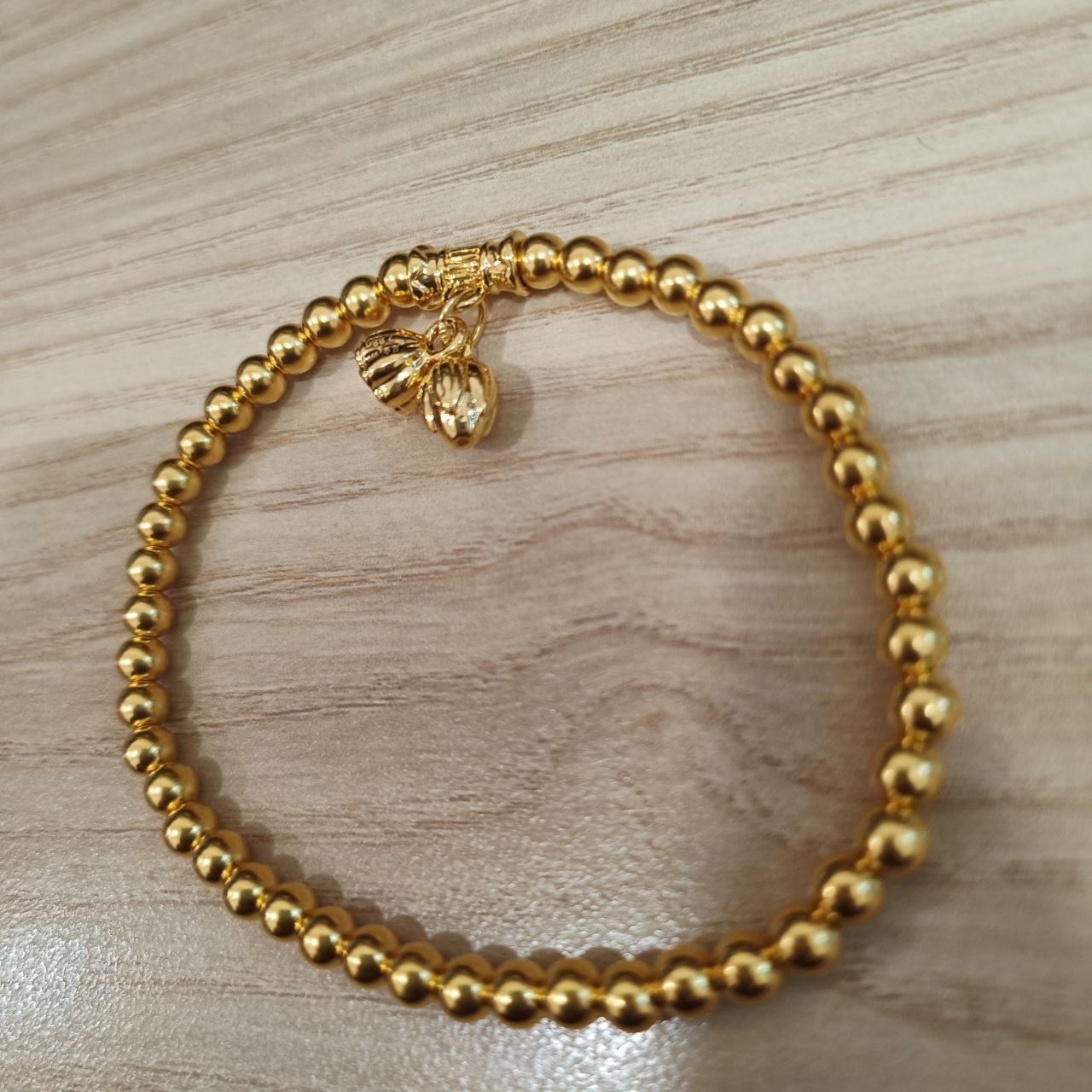 999 gold bead lotus bracelet showing floral charms - angled view
