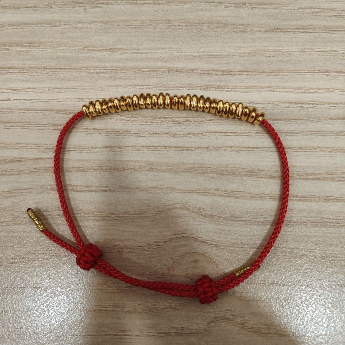 999 gold bead strand bracelet with adjustable red cord - full view