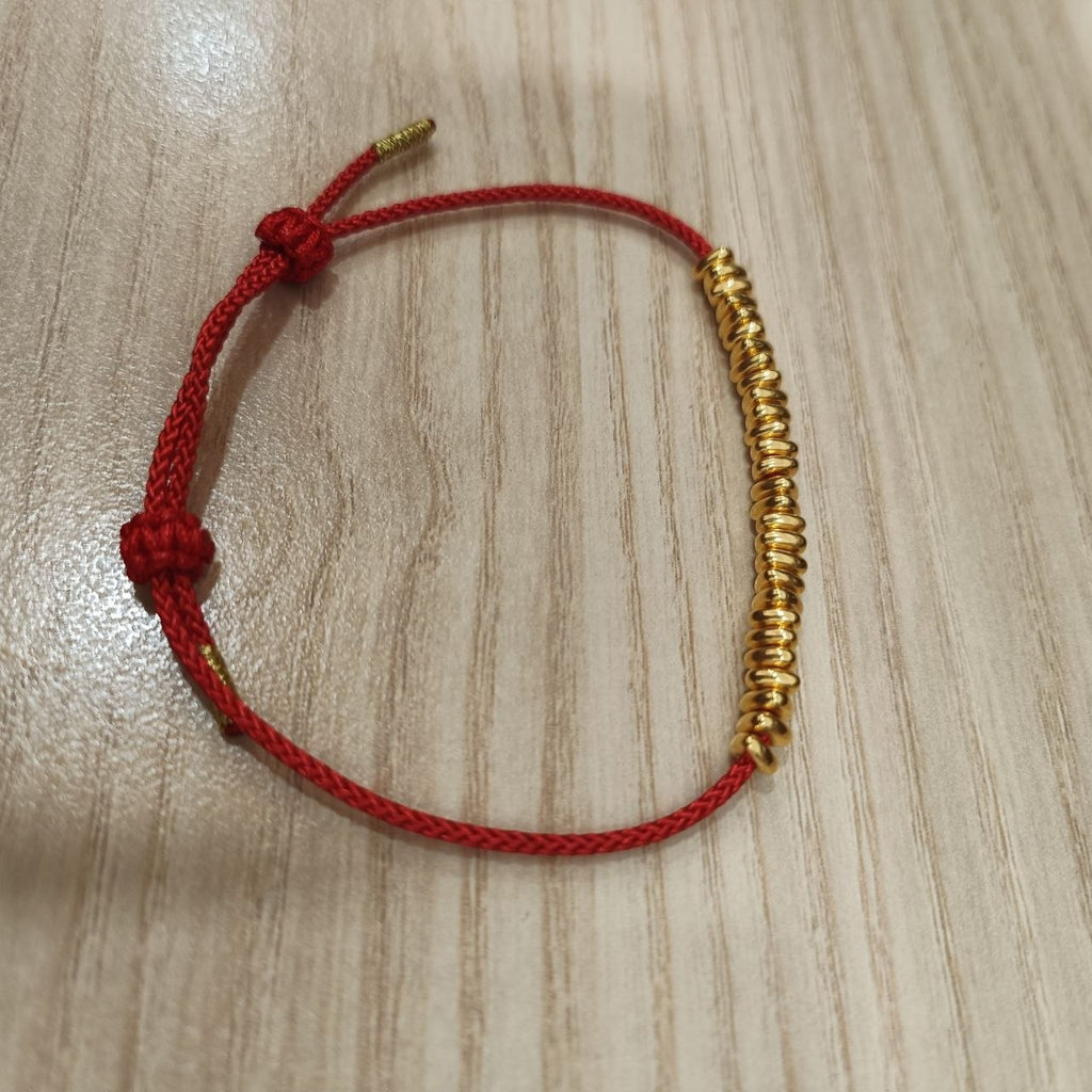 999 gold bead strand bracelet showing sliding knot - side view