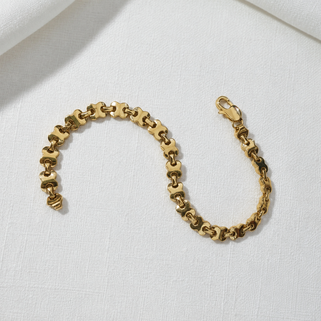 22K / 916 gold geometric-link bracelet laid open on white fabric, showing the full design and lobster clasp
