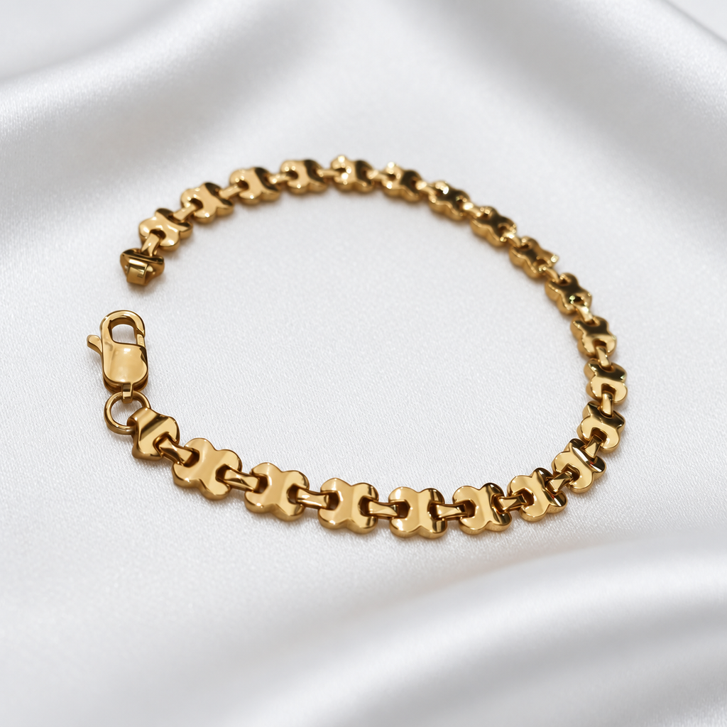 22K / 916 gold geometric-link bracelet arranged in a loop on white satin, showing the links and clasp