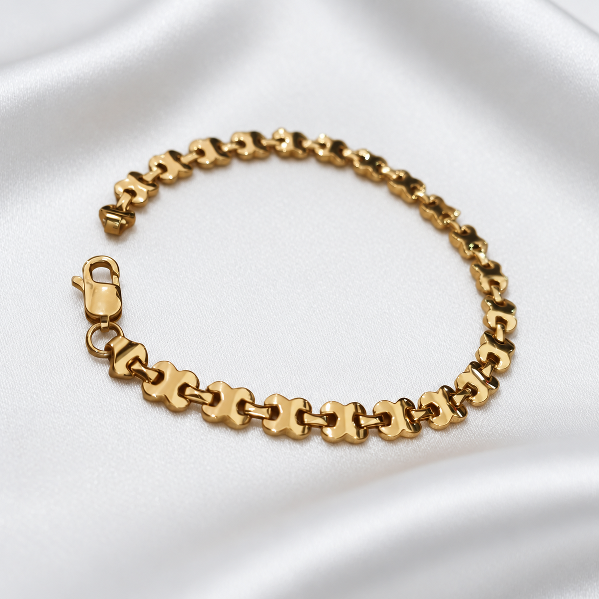 22K / 916 gold geometric-link bracelet arranged in a loop on white satin, showing the links and clasp