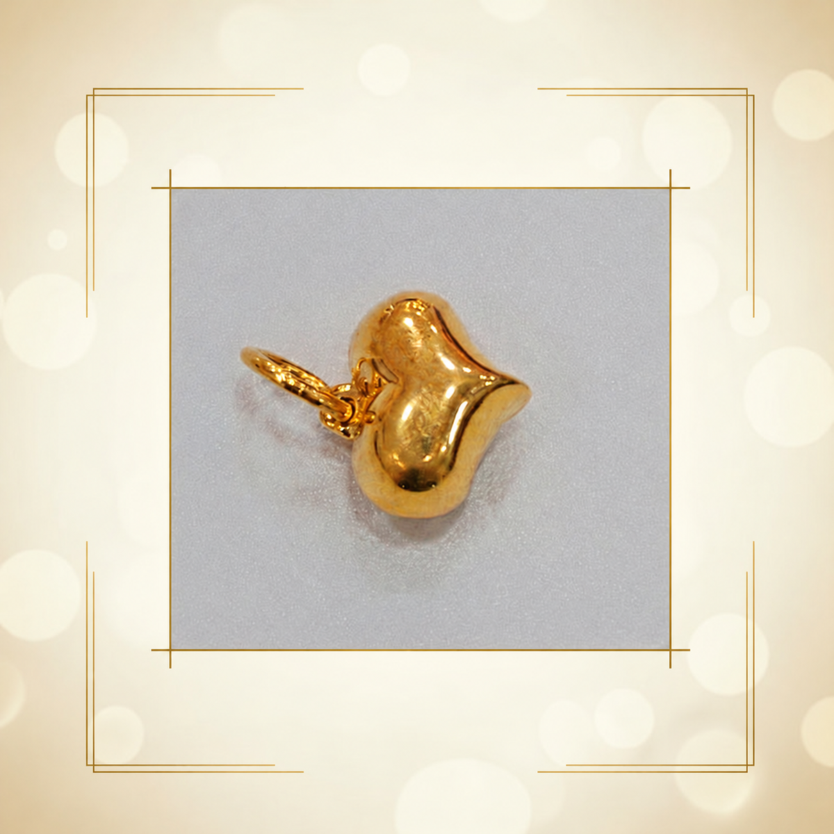 Sculpted polished 916 gold heart pendant shown at an angle on a grey inset background
