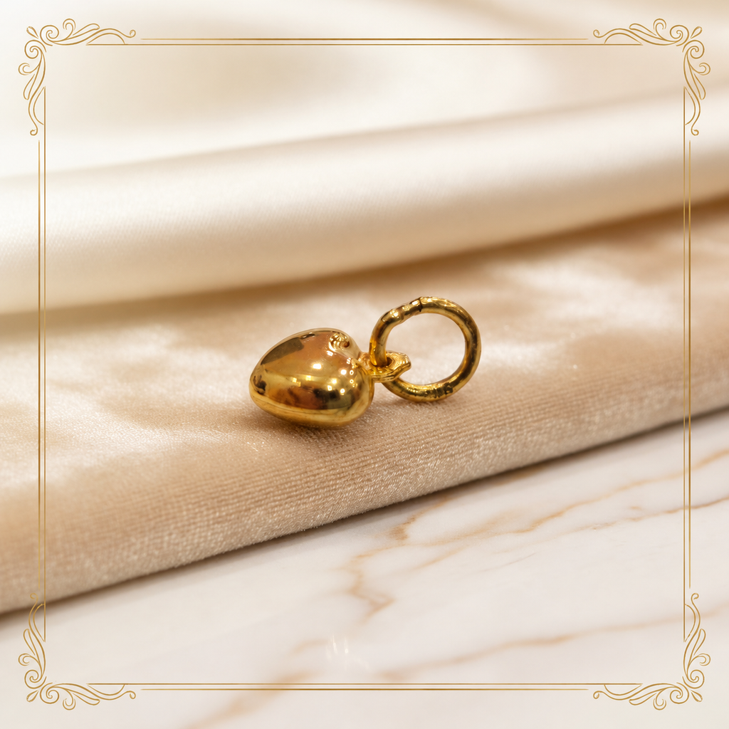 Side view of a polished 916 gold heart pendant resting on satin