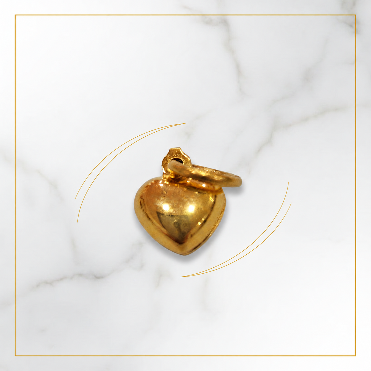 Polished 916 gold heart pendant with its loop resting across the top on pale marble
