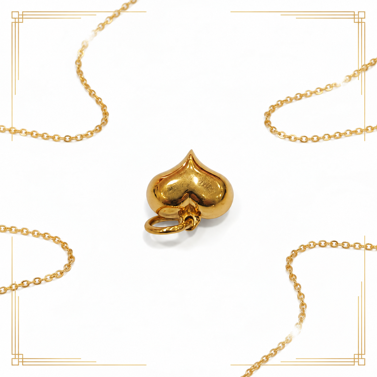 Polished 916 gold heart pendant shown upside down beside a fine chain on white