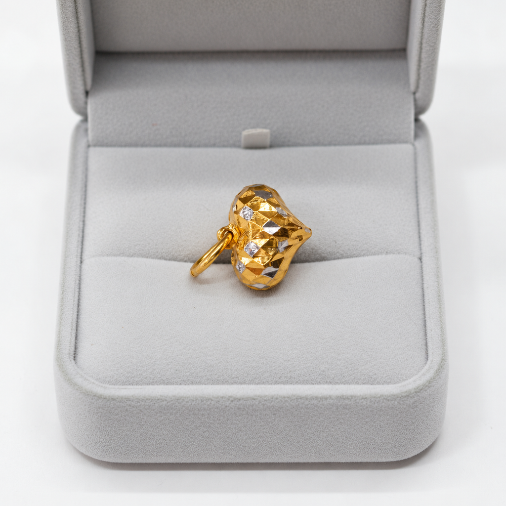 Faceted two-tone 916 gold heart pendant resting in a grey jewellery box
