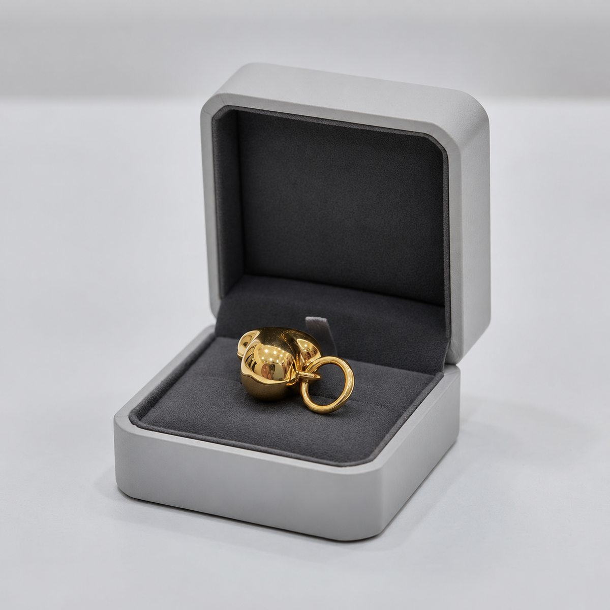 Polished 916 gold heart pendant resting in an open grey and black jewellery box