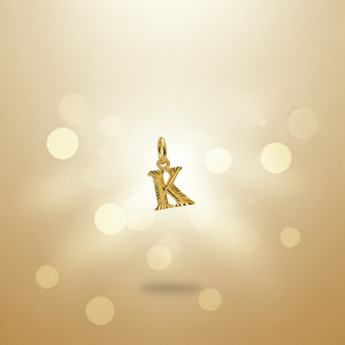 Guild Bullion 916 gold letter K pendant with cut edges on a warm gold background
