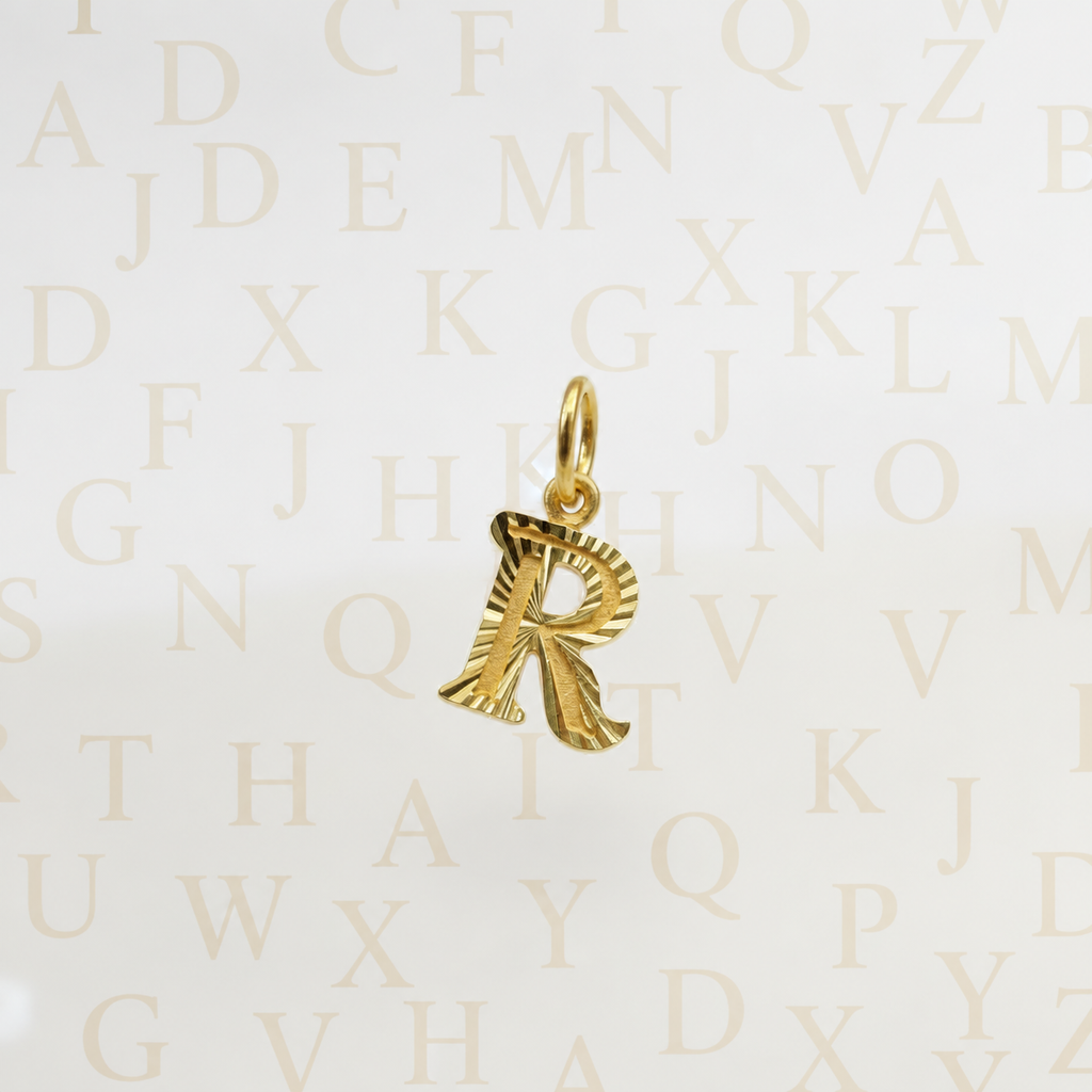 Guild Bullion 916 gold letter R pendant with hanging loop on an alphabet background