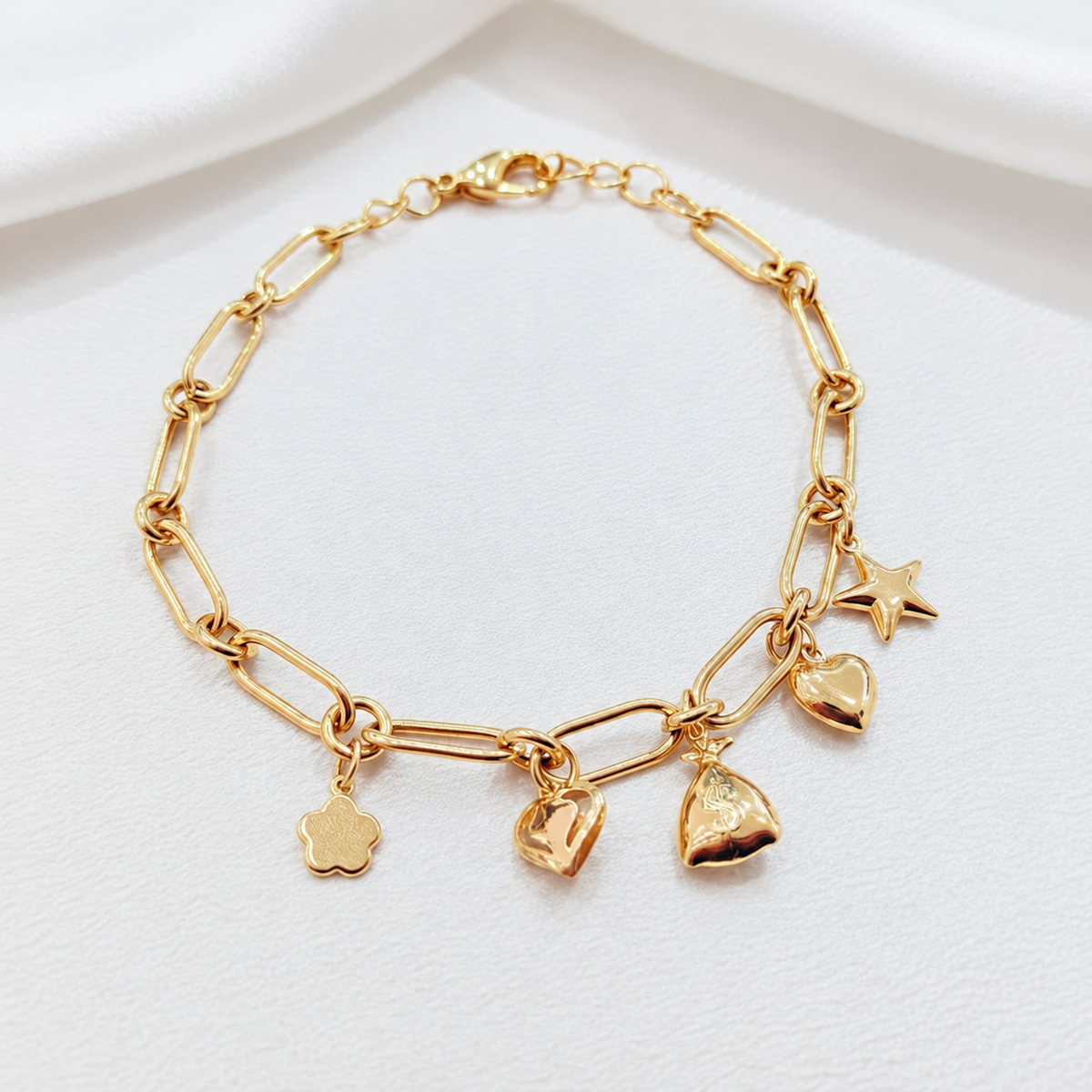 Earlier anchor link bracelet with flower, heart, pouch and star charms on satin; design reference only