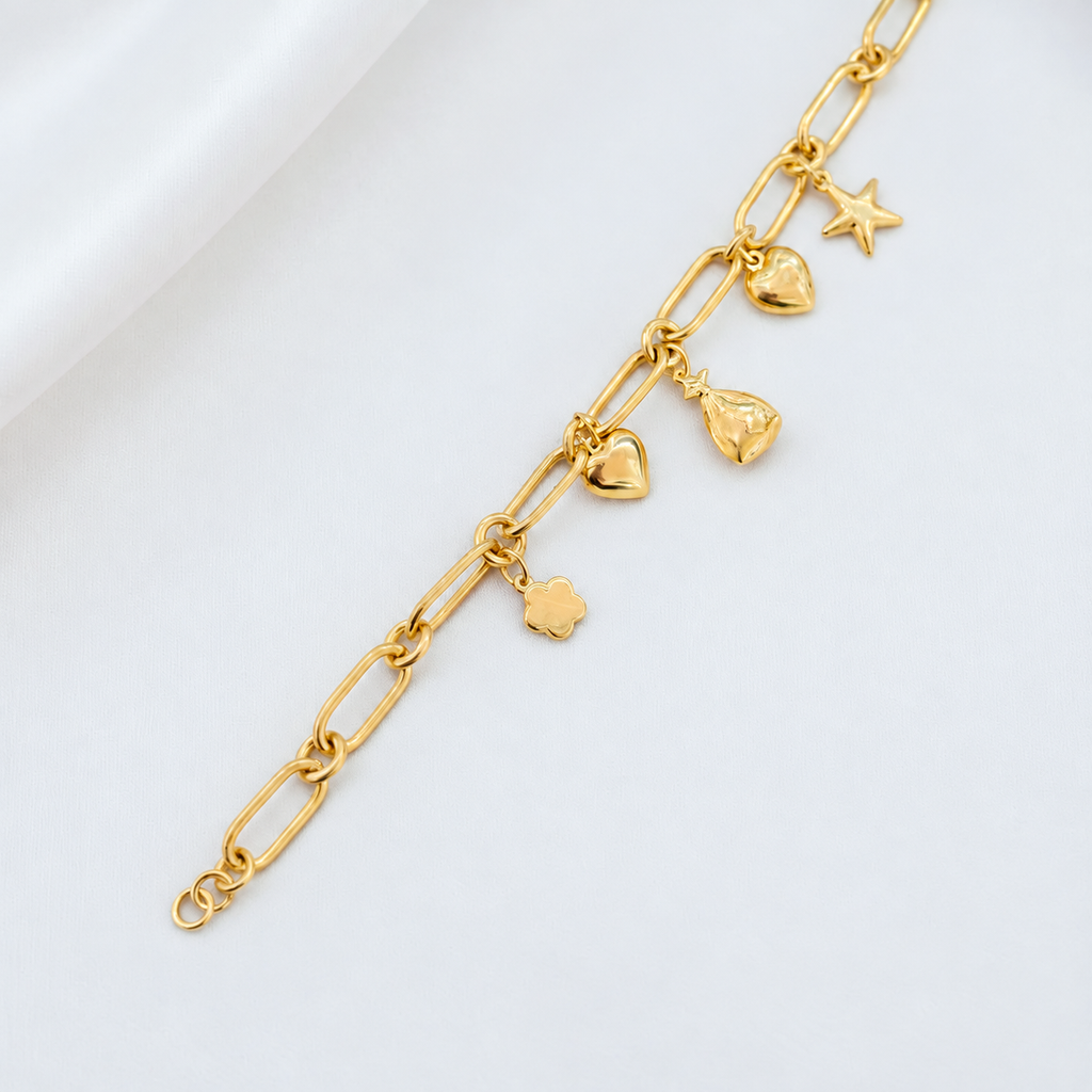 Earlier anchor link bracelet laid diagonally on satin with five charms; design reference only