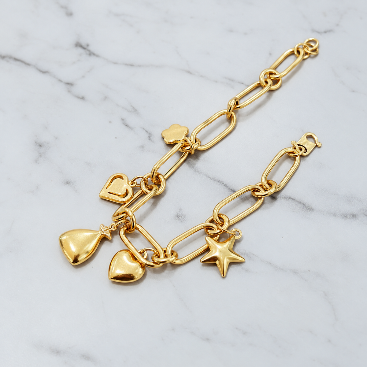 Earlier anchor link charm bracelet on marble with heart, pouch and star motifs; design reference only