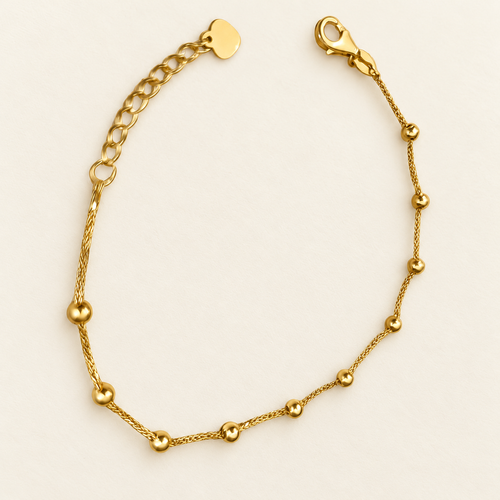 Alternate full view of the 916 gold Fancy Bead Station Bracelet on an ivory background