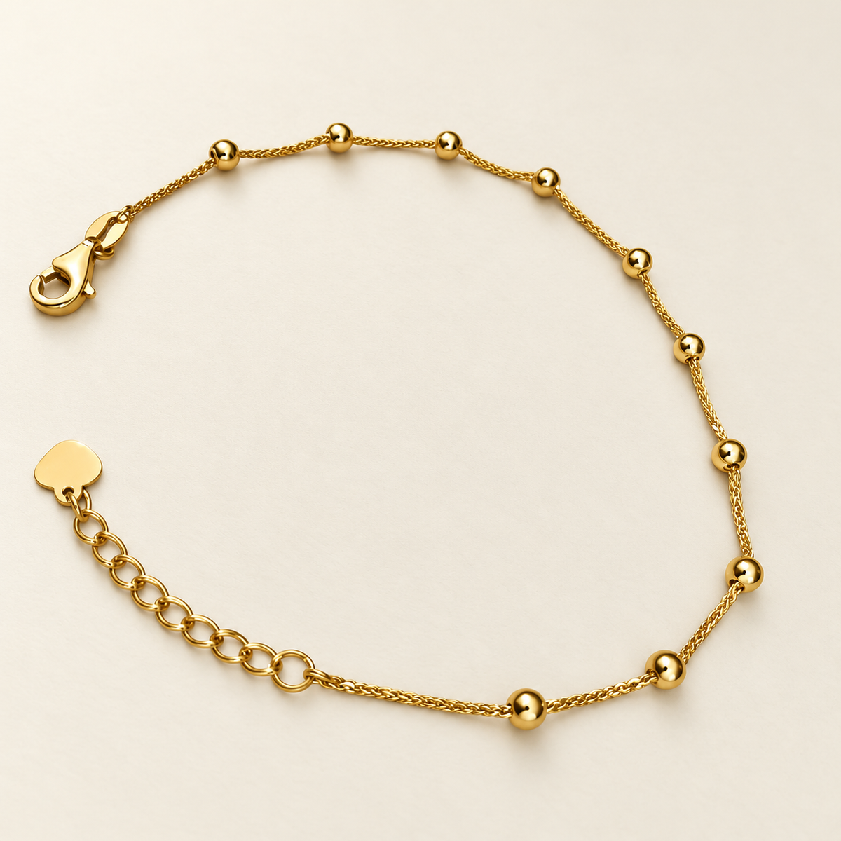 Detail view of polished bead stations and extension links on the adjustable 22K gold bracelet