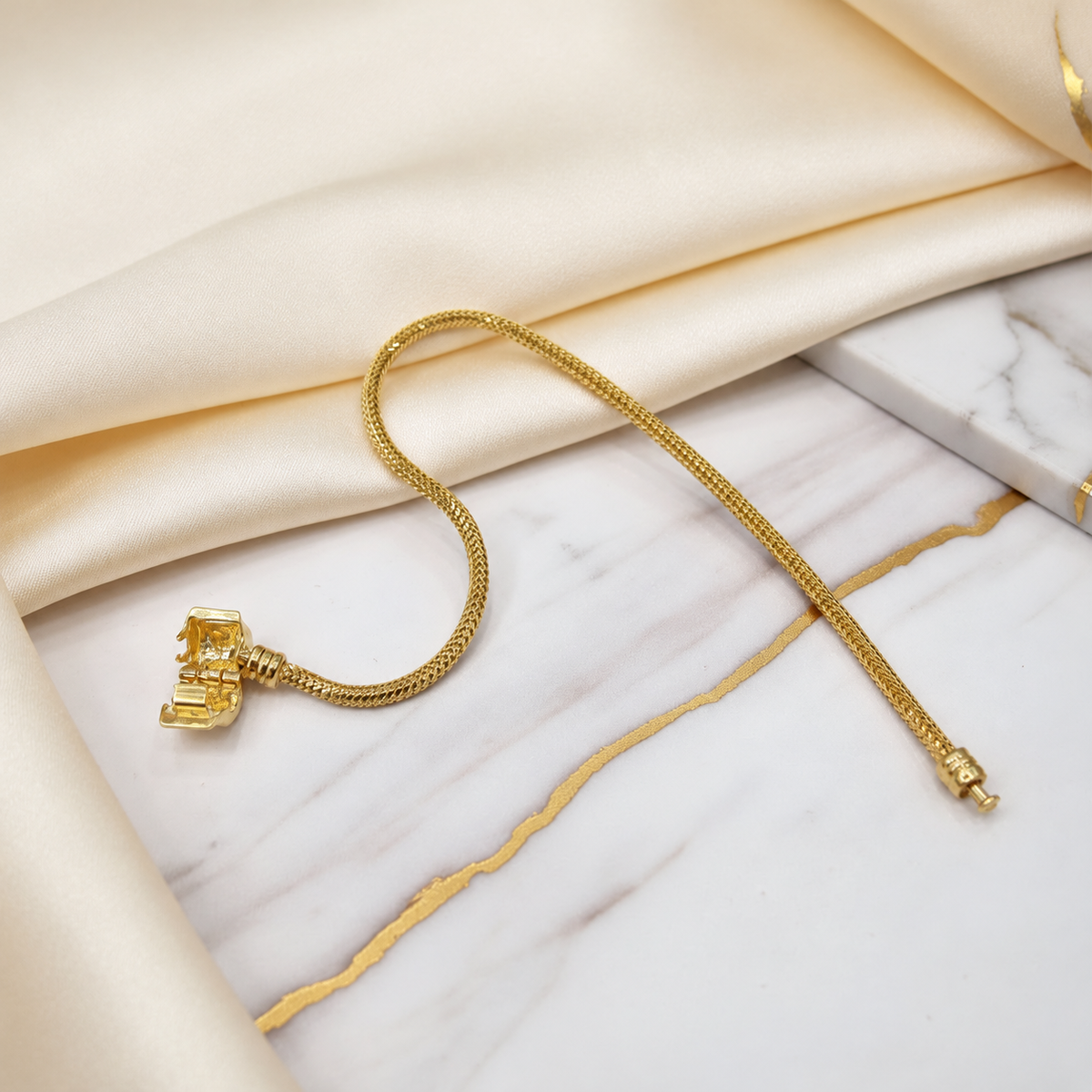Guild Bullion 22K / 916 gold Charm-Cut Bracelet showing the open hinged barrel clasp and chain terminal on marble