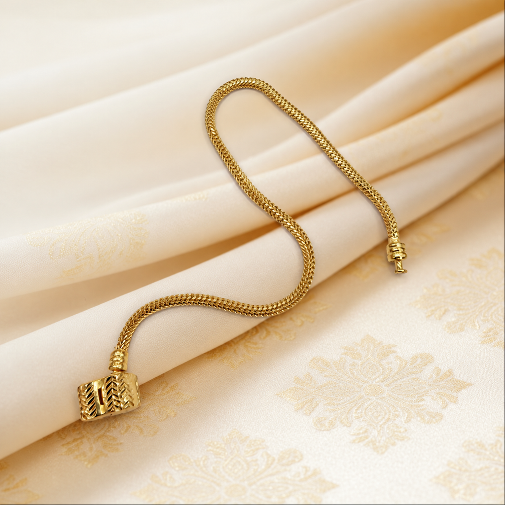 Guild Bullion 22K / 916 gold Charm-Cut Bracelet showing fine chain texture and decorative barrel clasp on patterned satin