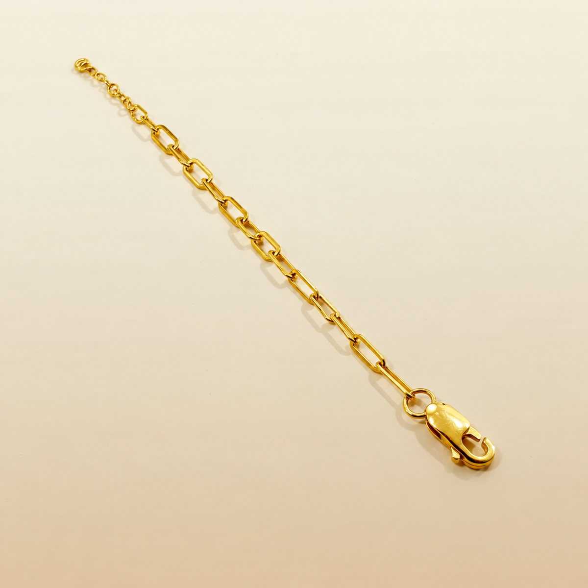 916 gold Clip Bracelet V3 on a cream background with lobster clasp and extension rings visible