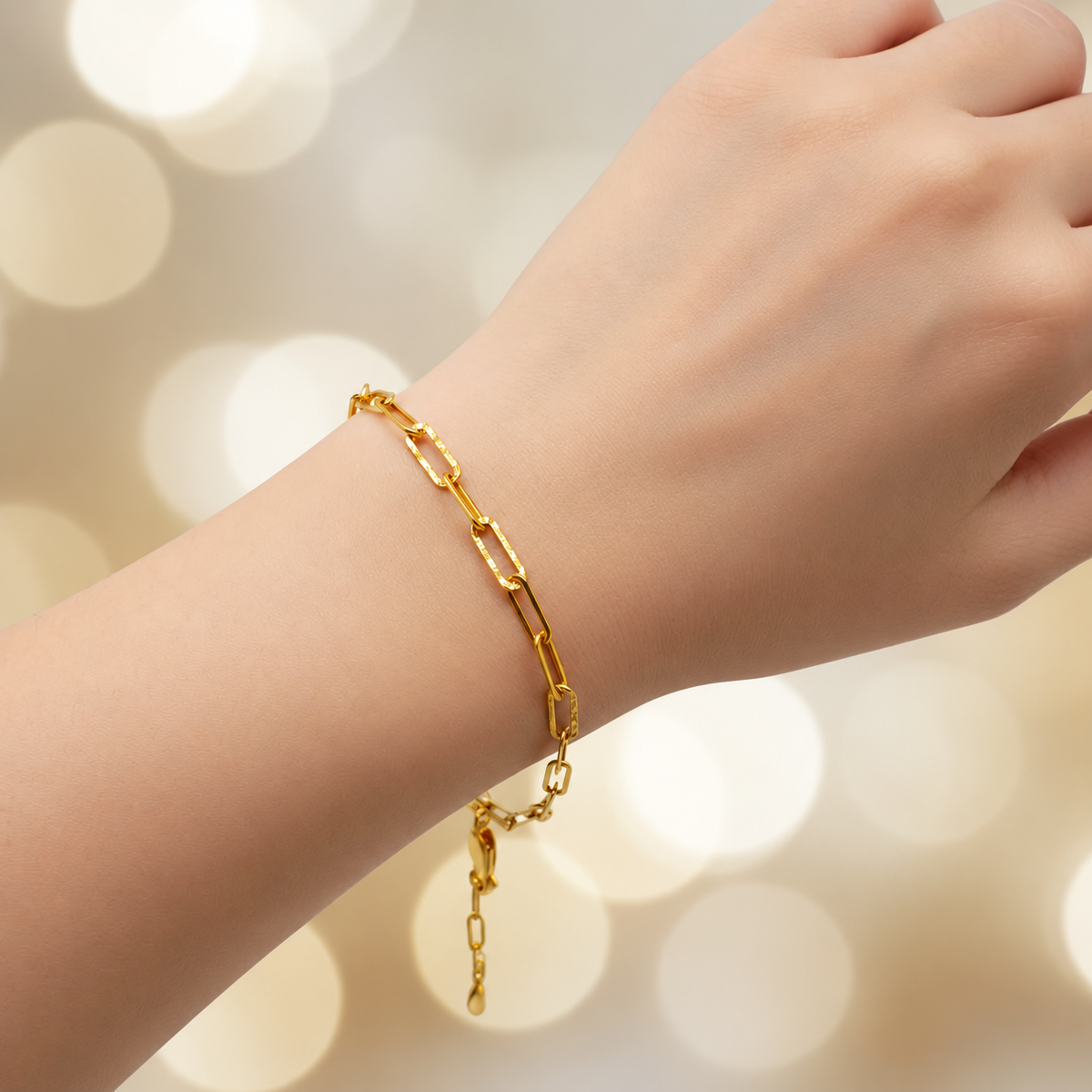 BR21199 916 gold Clip Bracelet V3 worn on a wrist, showing elongated links, faceted details and extension chain