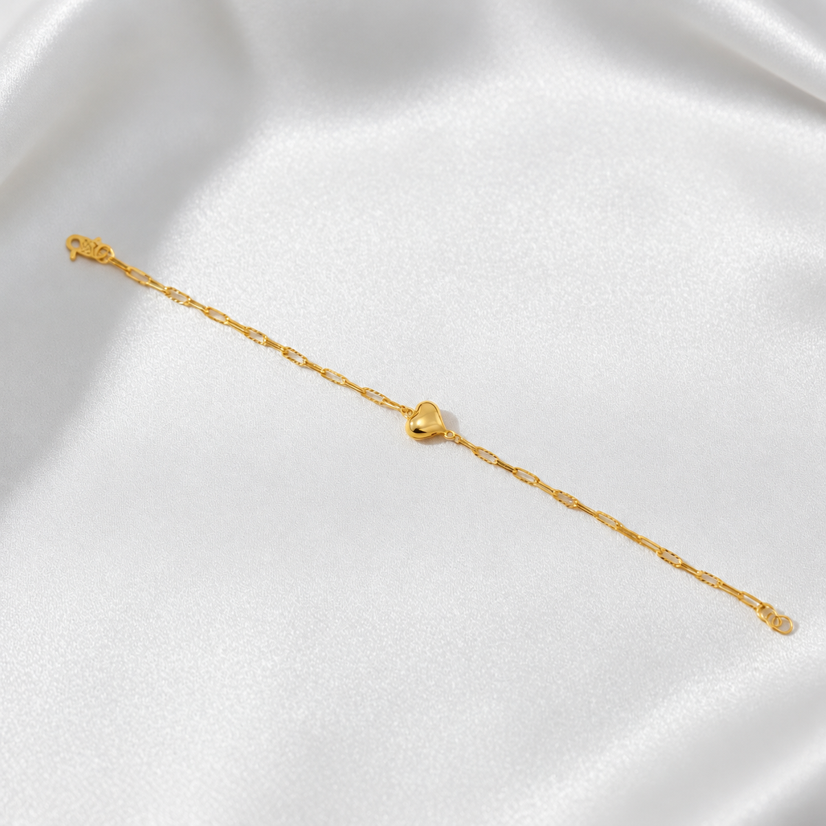 BR24467 916 gold Clip-Link Heart Bracelet shown at full length on white satin with polished heart, S-hook clasp and end rings