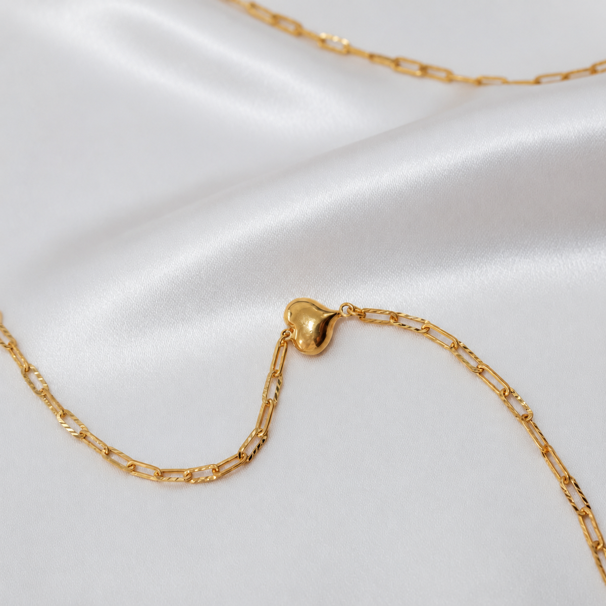 Detail of the polished heart and faceted elongated links on the 916 gold Clip-Link Heart Bracelet