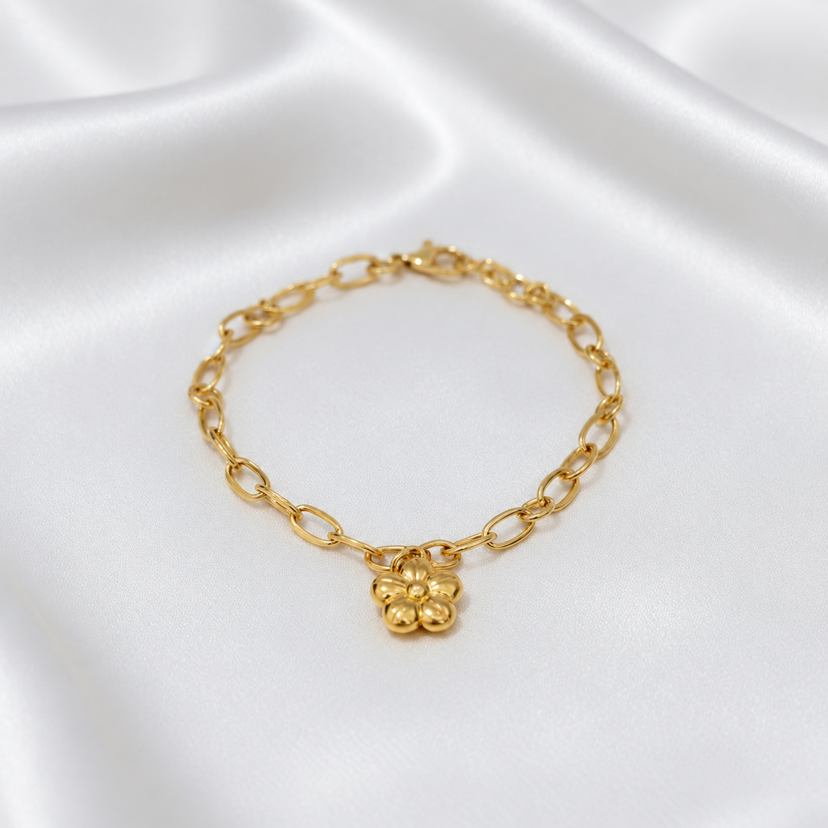 Front view of the 916 gold five-petal flower charm link bracelet arranged on white satin