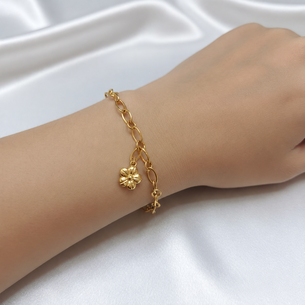 916 gold flower charm link bracelet worn on a wrist, showing the five-petal charm and oval links