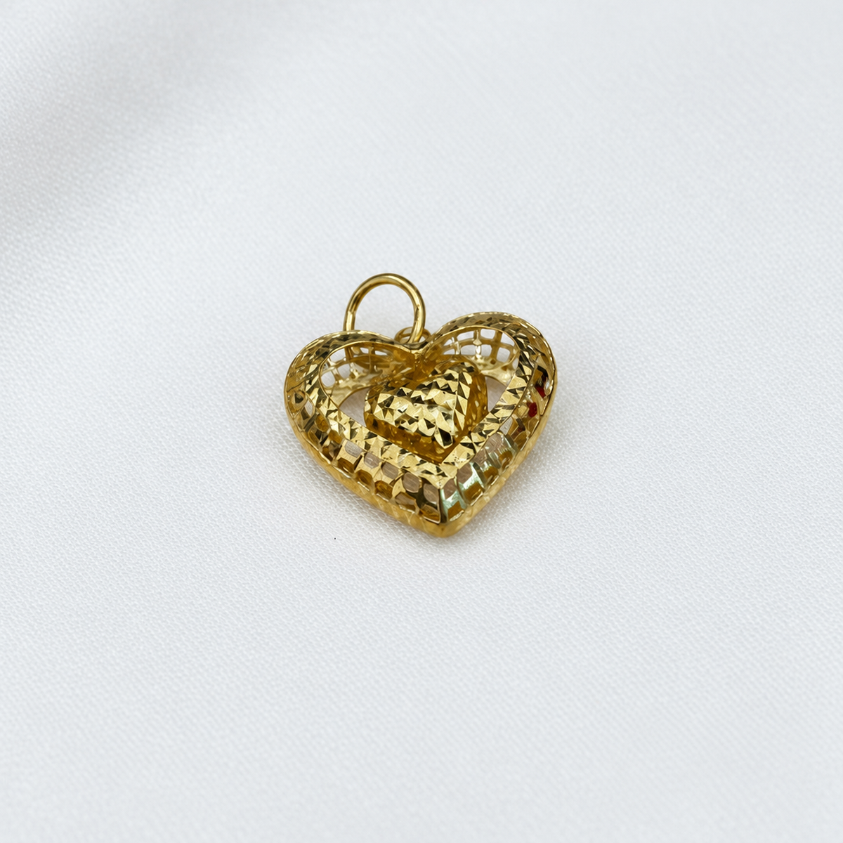Close-up of the 916 gold dangling heart pendant showing textured open frame and faceted centre