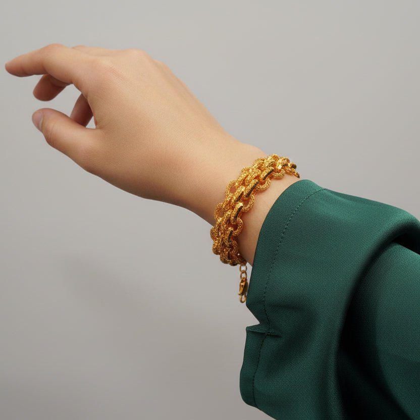 916 gold double-link bracelet worn beside a green sleeve with extension chain visible