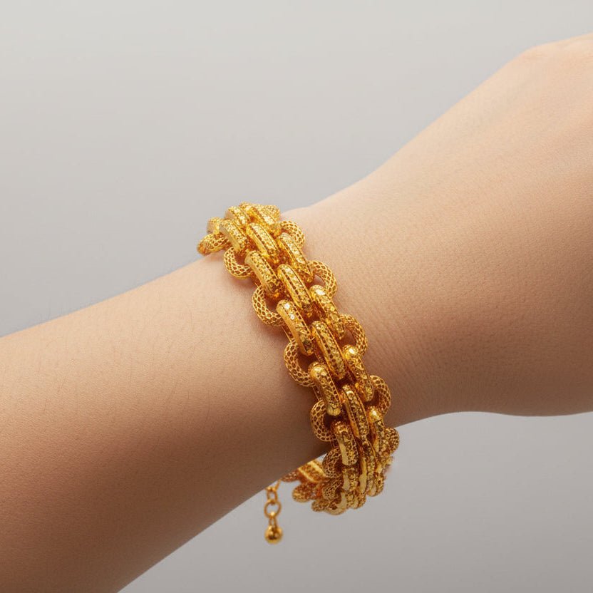 Close view of the textured 916 gold double-link bracelet worn on a wrist