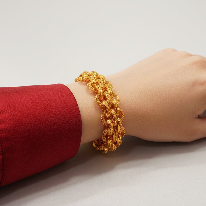 916 gold double-link bracelet worn on a wrist beside a red sleeve