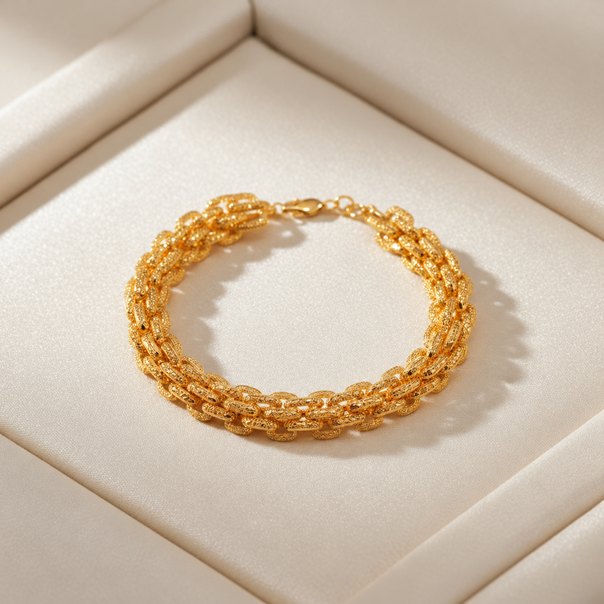 916 gold double-link bracelet arranged in an oval on a plain cream jewellery tray