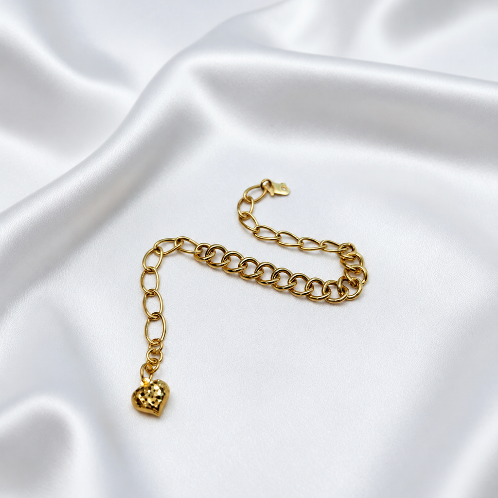 916 gold dual design link bracelet with heart charm arranged in an S curve on satin