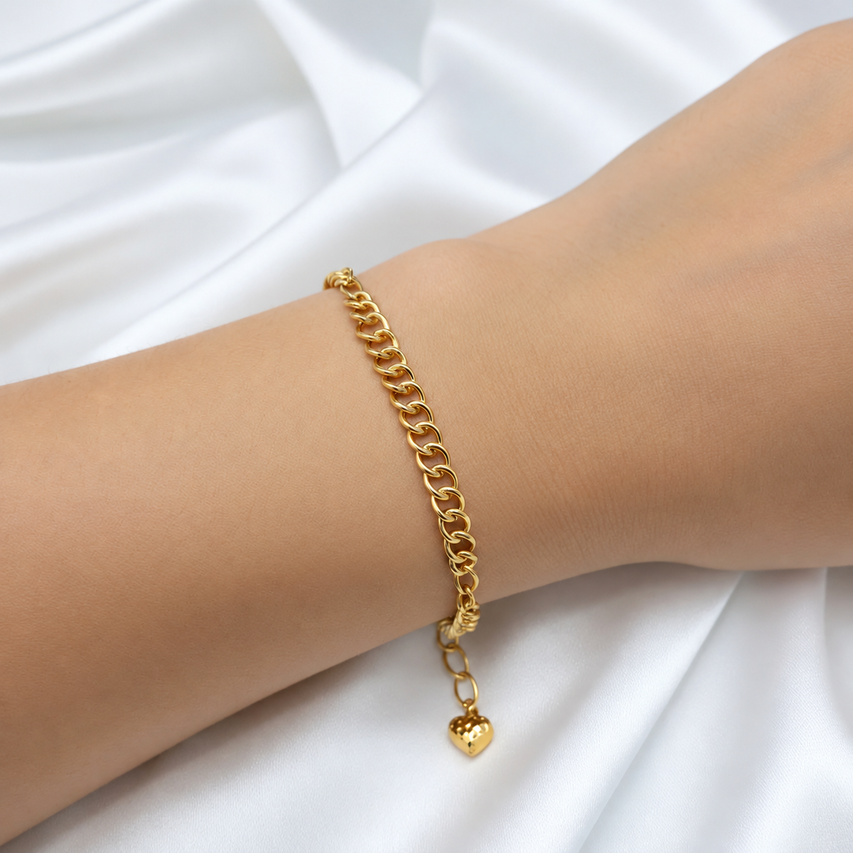 916 gold dual design link bracelet worn on a wrist with dangling heart charm