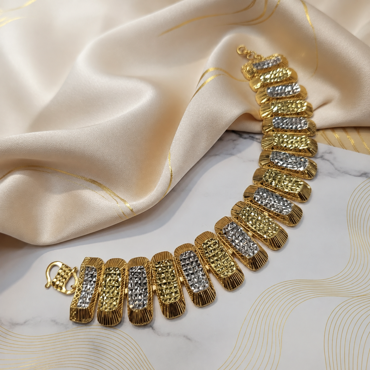 916 gold dual-tone rectangular bracelet BR20979 with textured links on cream satin
