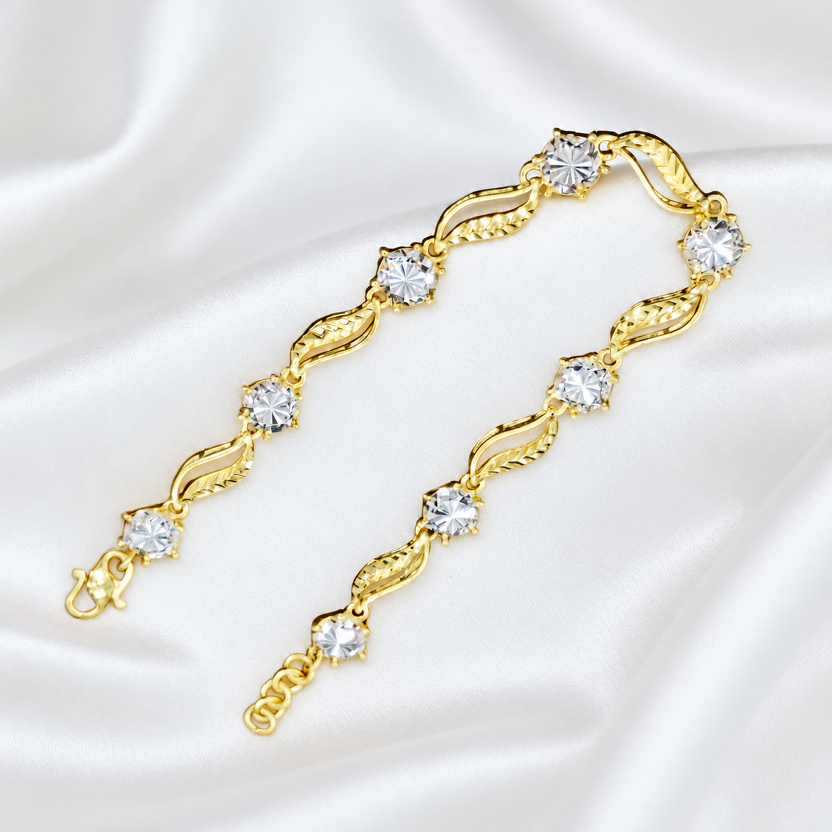 Reference leaf-link bracelet with round silver-coloured accents and hook clasp on white satin
