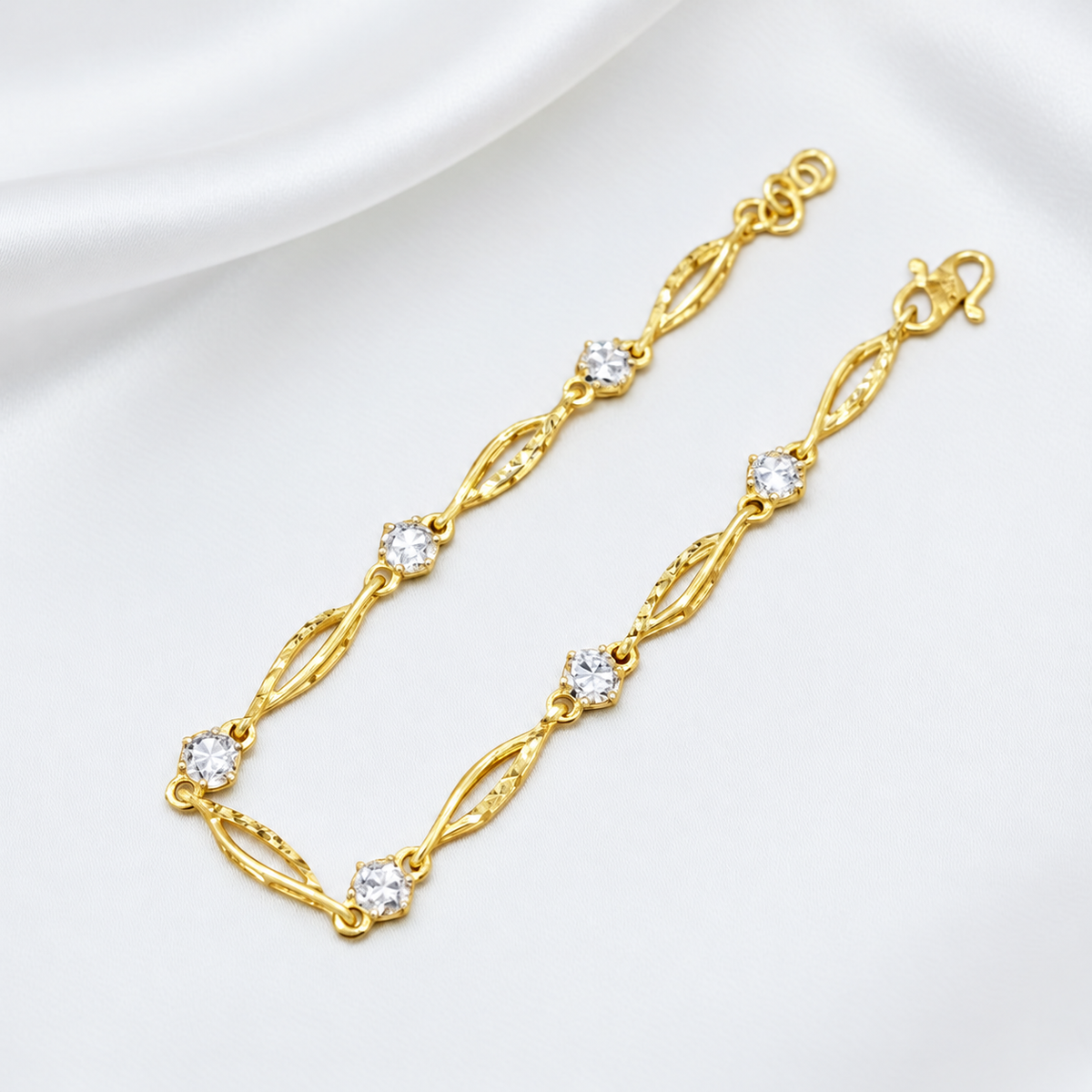 Reference narrow open marquise-link bracelet with round silver-coloured accents on white satin