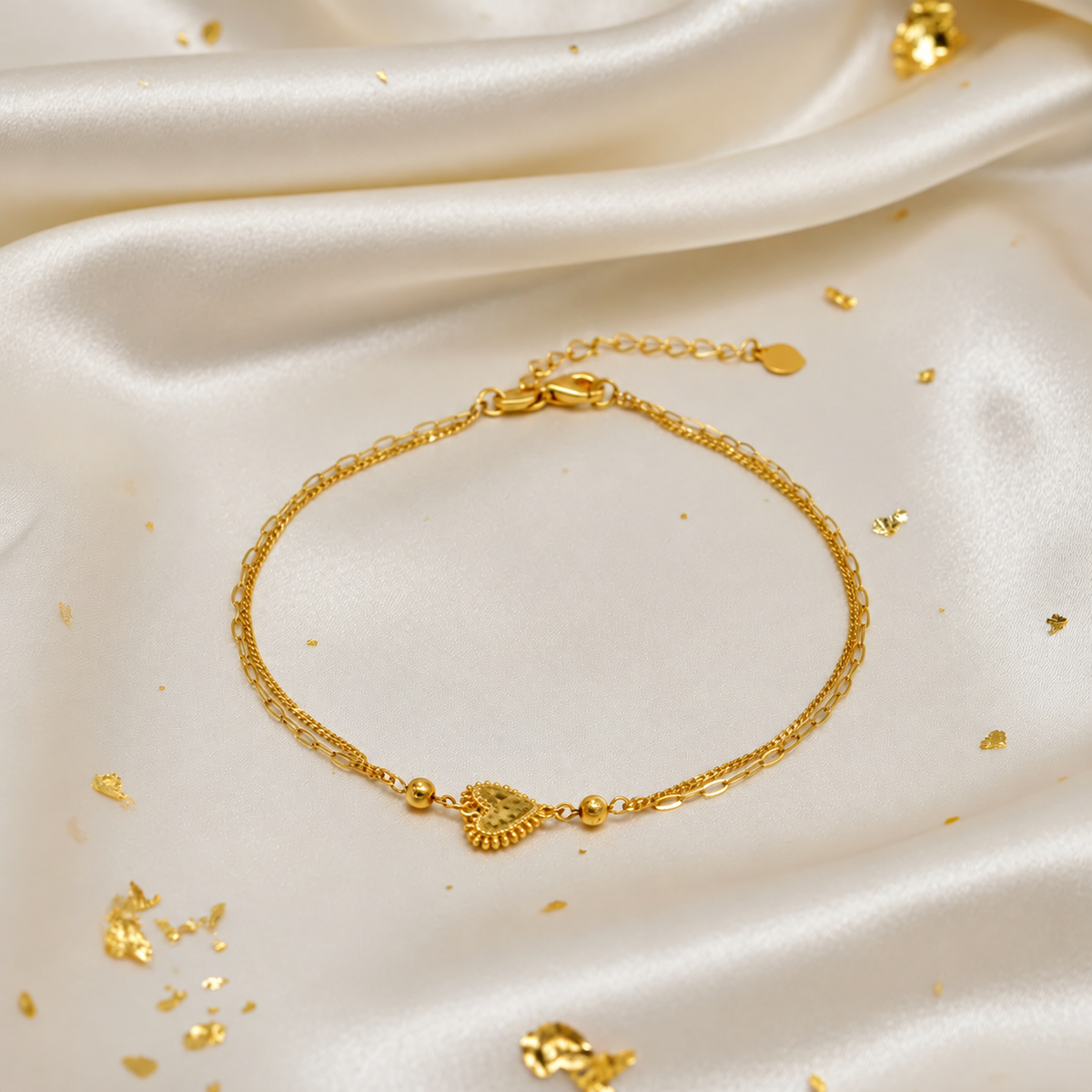 BR23423 916 gold Elegant Heart and Bead Bracelet on cream satin, showing heart centrepiece, two beads and adjustable extension