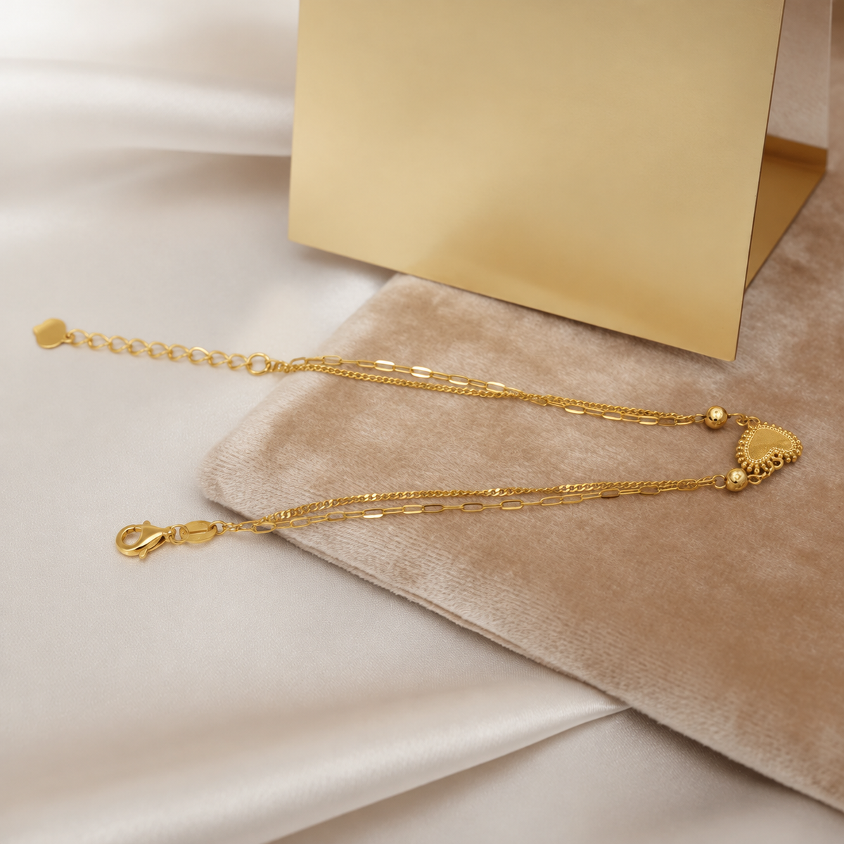 Extended BR23423 22K gold heart and bead bracelet showing lobster clasp, chain strands and extension rings beside a blank display card